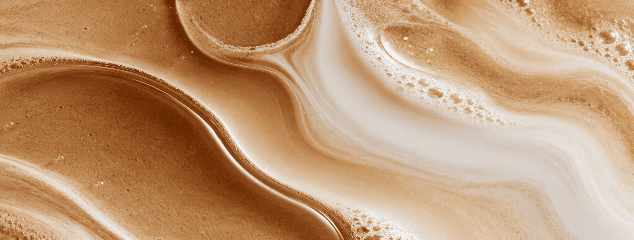 Courbes crémeuses et marbrées de mousse de café et de lait, aux tons beige et caramel, texture abstraite