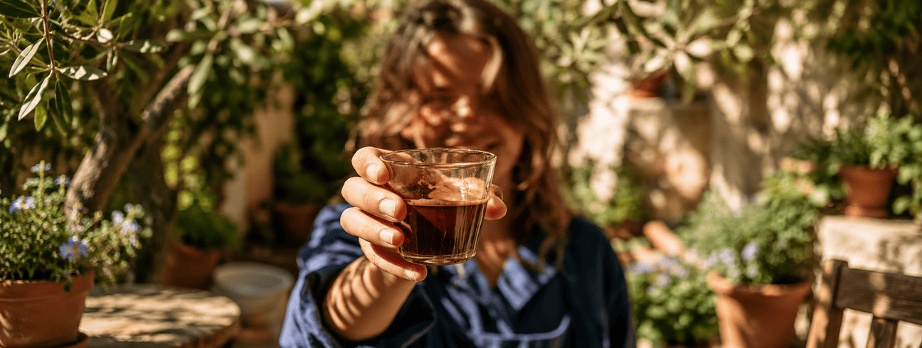 Portrait d'une femme souriante en plein soleil, illustration des leviers du quotidien au-delà du café (sommeil, mouvement, alimentation)